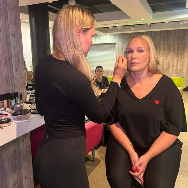 make-up student applying make-up at fashion show